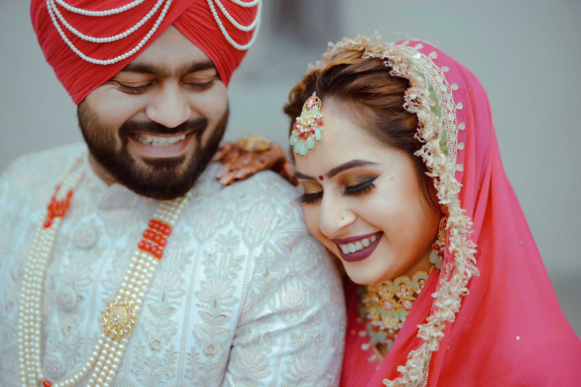 Smiling Indian couple in traditional wedding attire, capturing joy and love.