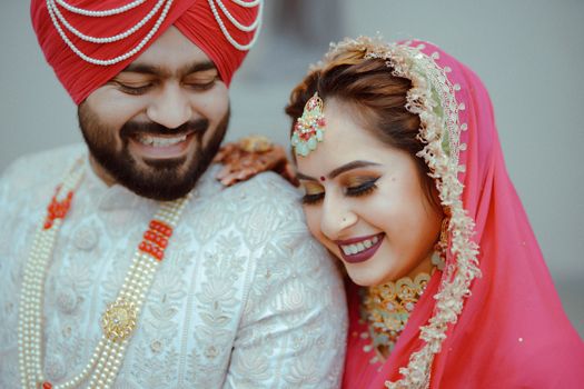 Smiling Indian couple in traditional wedding attire, capturing joy and love.