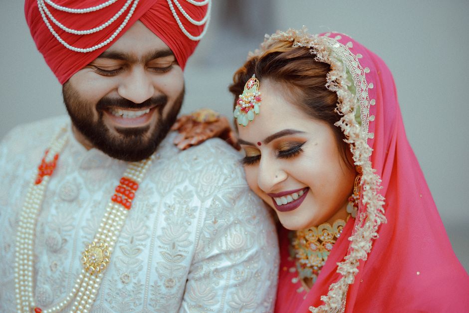 Smiling Indian couple in traditional wedding attire, capturing joy and love.