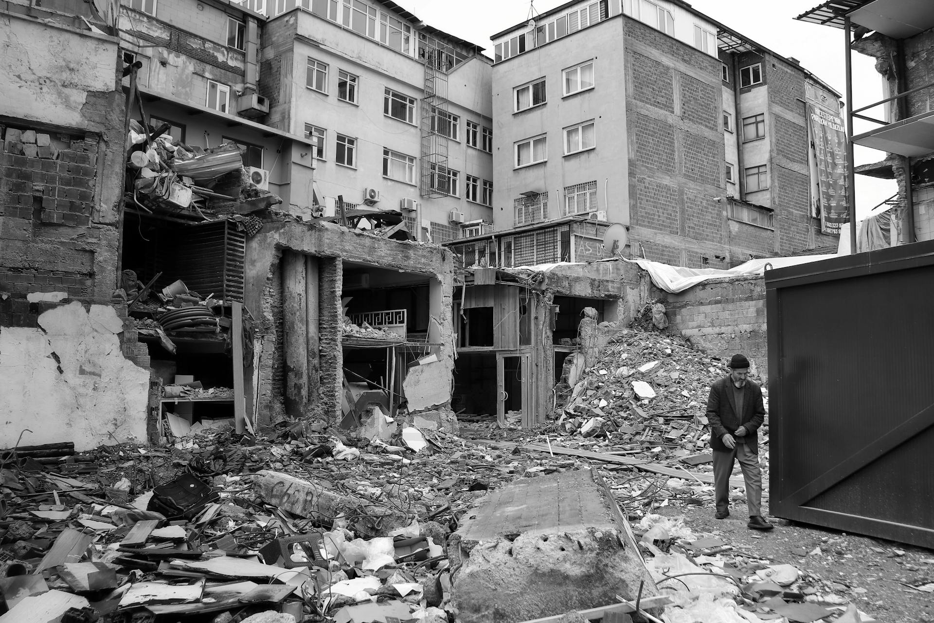 Man Walking among the Rubble of a Ruined City after an Earthquake