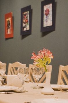 Charming dining room setup with floral centerpiece and wall art, creating an inviting atmosphere.