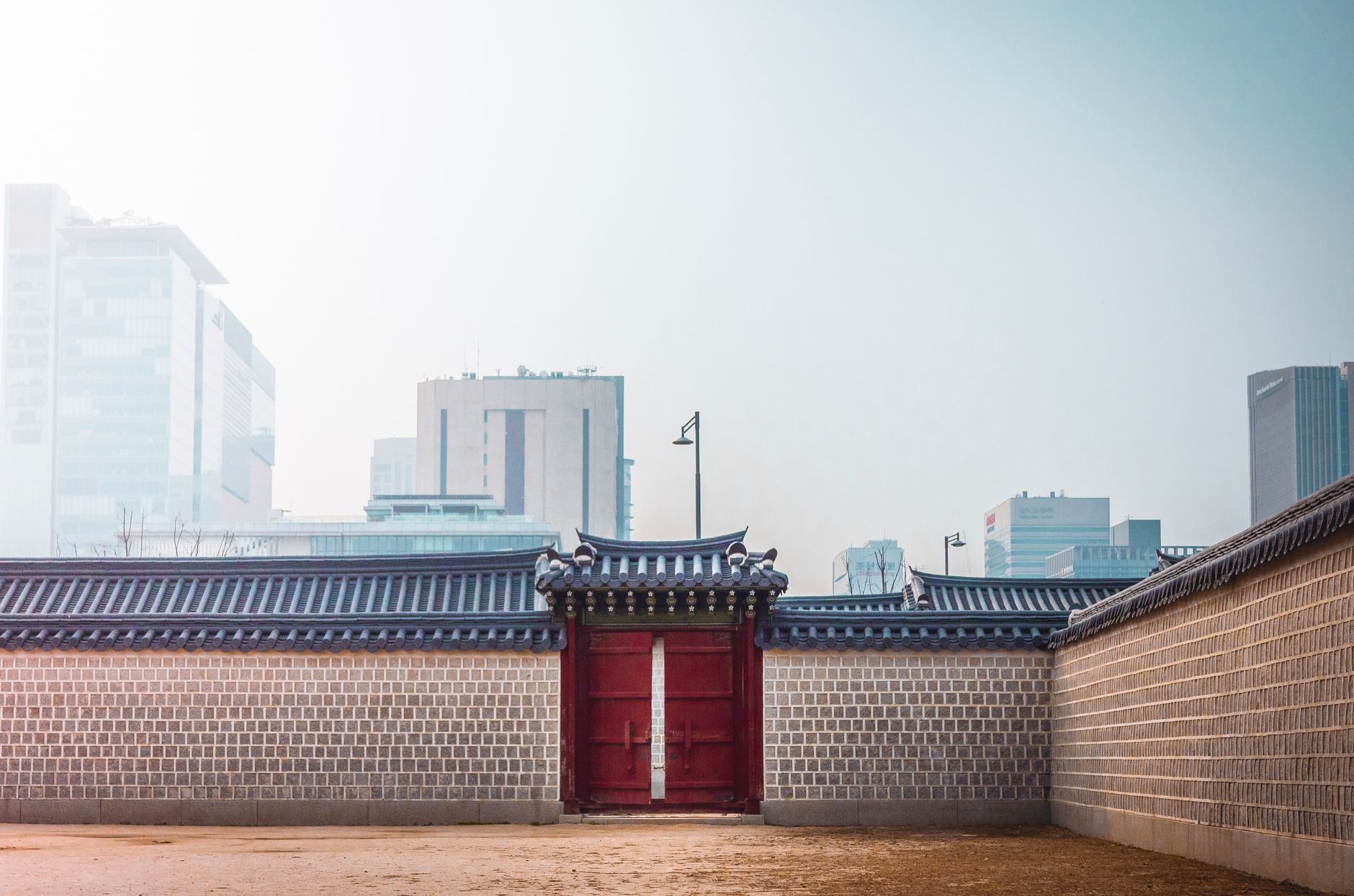 Gyeongbokgung Palace with a backdrop of modern Seoul skyscrapers, symbolizing old and new Korea