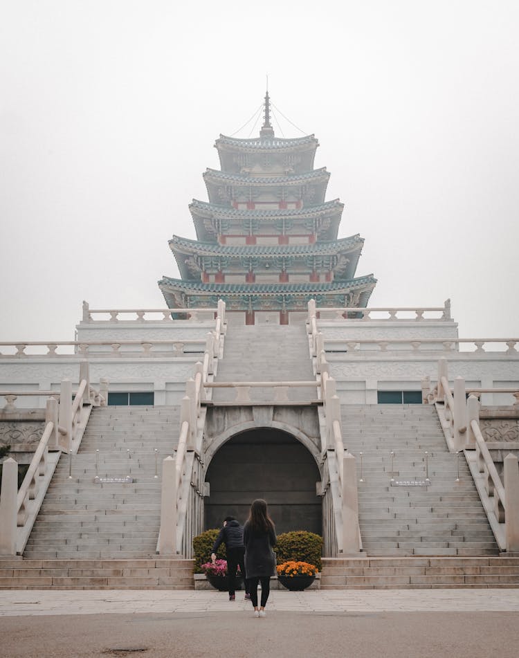 Two People Standing In Front Of Temple