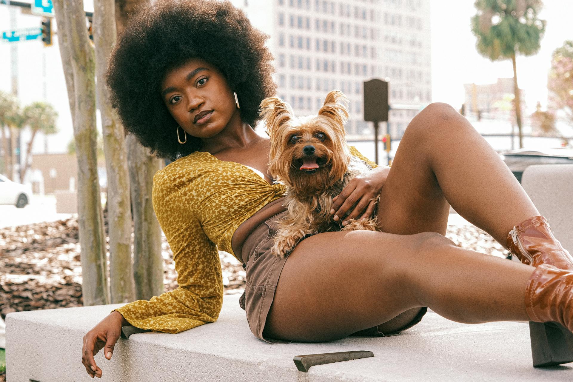 Young Woman in a Fashionable Summer Outfit Lying Outside with Her Little Dog