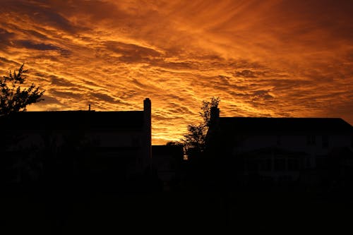 免費 夕陽下的橙色天空下的建築物的輪廓 圖庫相片