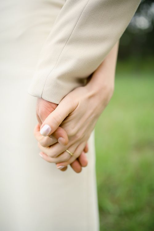 Free Close-up of a couple holding hands, symbolizing connection and love in a natural setting. Stock Photo
