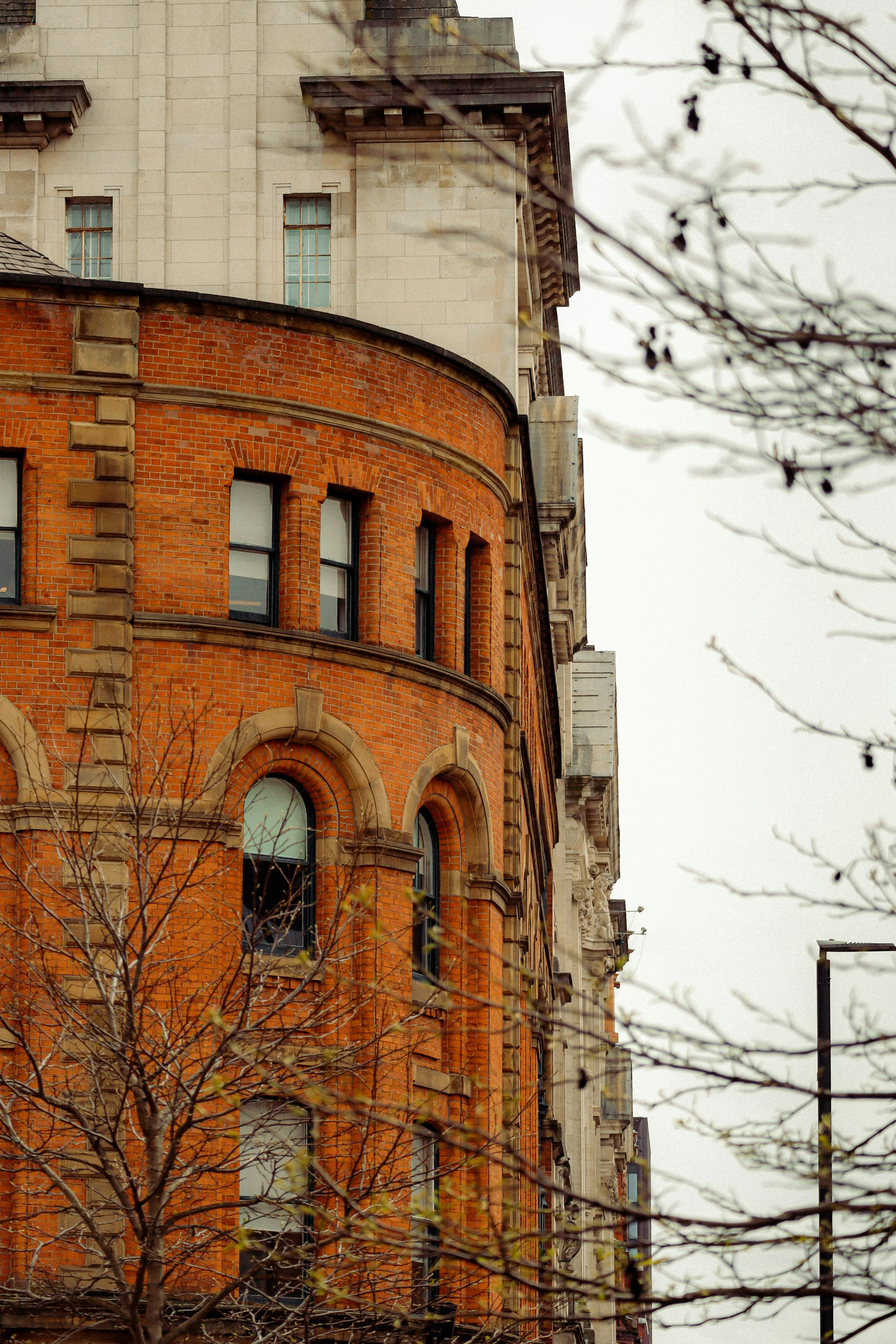 Free Close-up of a vintage brick building's facade showcasing architectural details in an urban setting. Stock Photo