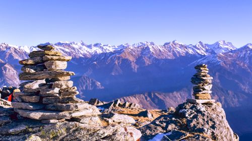 Free Scenic view of stacked stones with the majestic Himalayan mountains at Singtur Range, India. Stock Photo