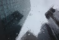 雨滴在窗户上泛起涟漪，映出城市的背景