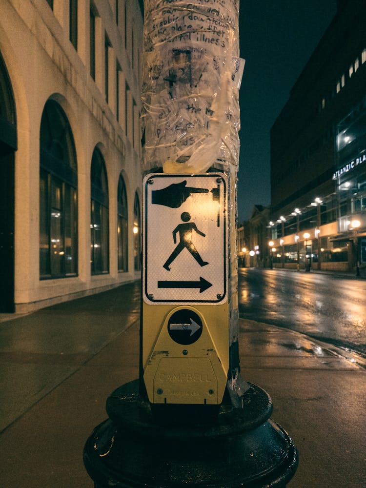 Road Sign On Pole Near Street At Night