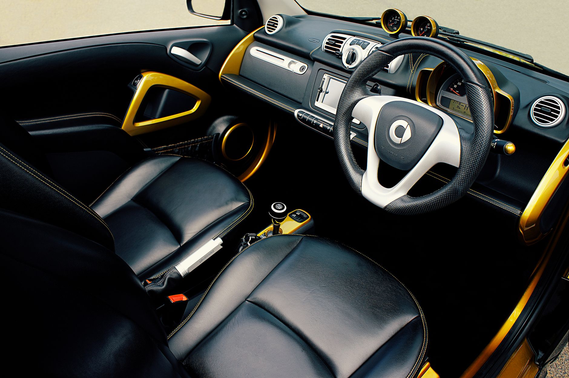 High-quality photo of a luxury car interior featuring leather seats and gold accents.