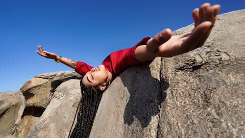 Woman Lying Down on Rock and Posing with Eyes Closed