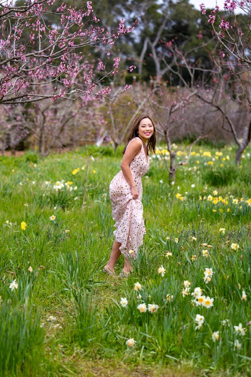 Smiling Asian Woman Walking in Blooming Garden