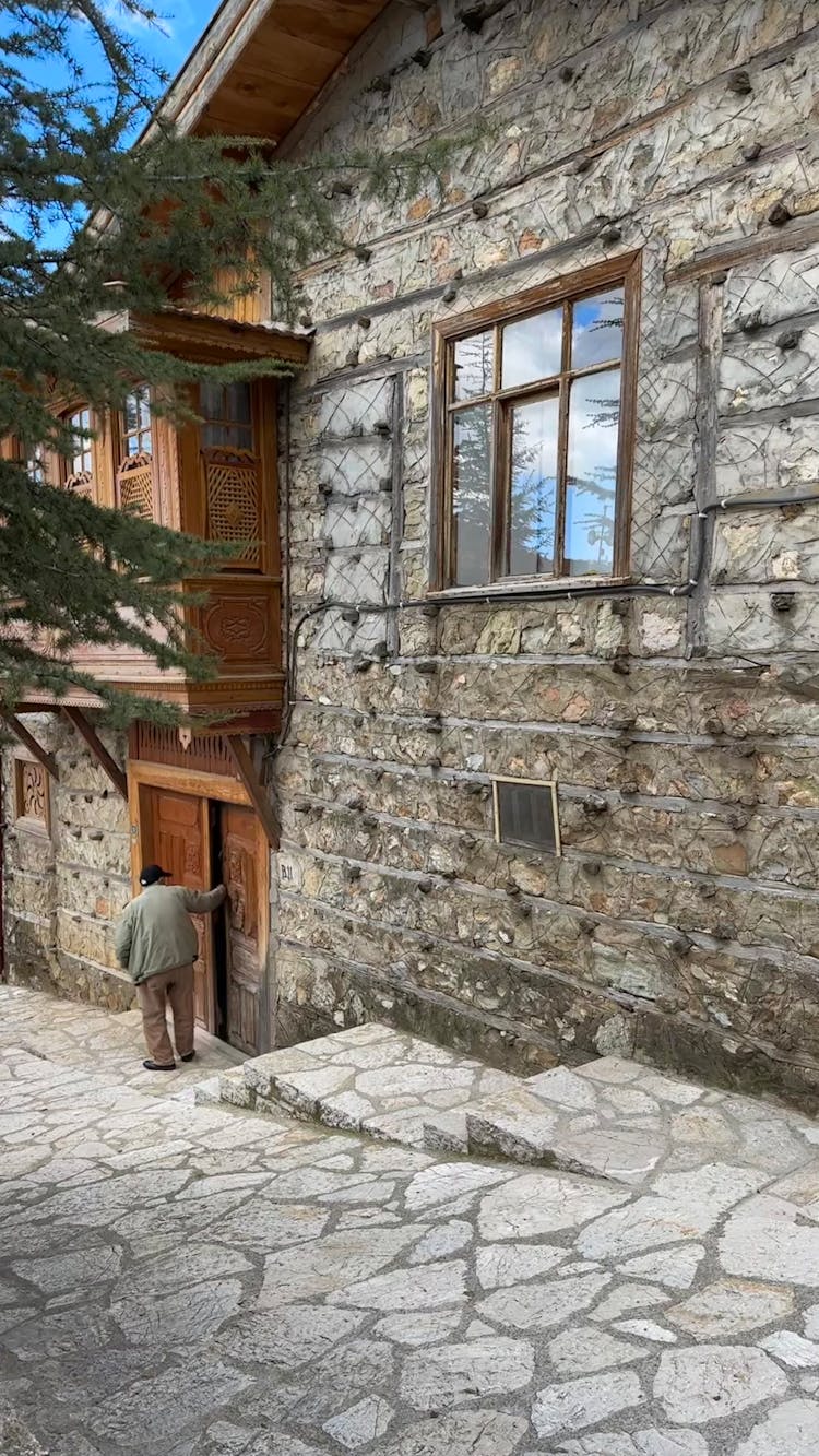 Man At Door Of Old Stone House