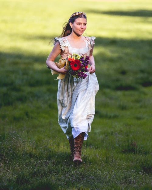 Woman in Cottagecore Dress Carrying Flowers