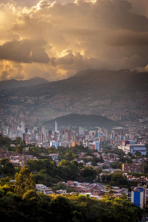 Free Beautiful Medellin cityscape with dramatic clouds and sunrise glow over the mountains. Stock Photo