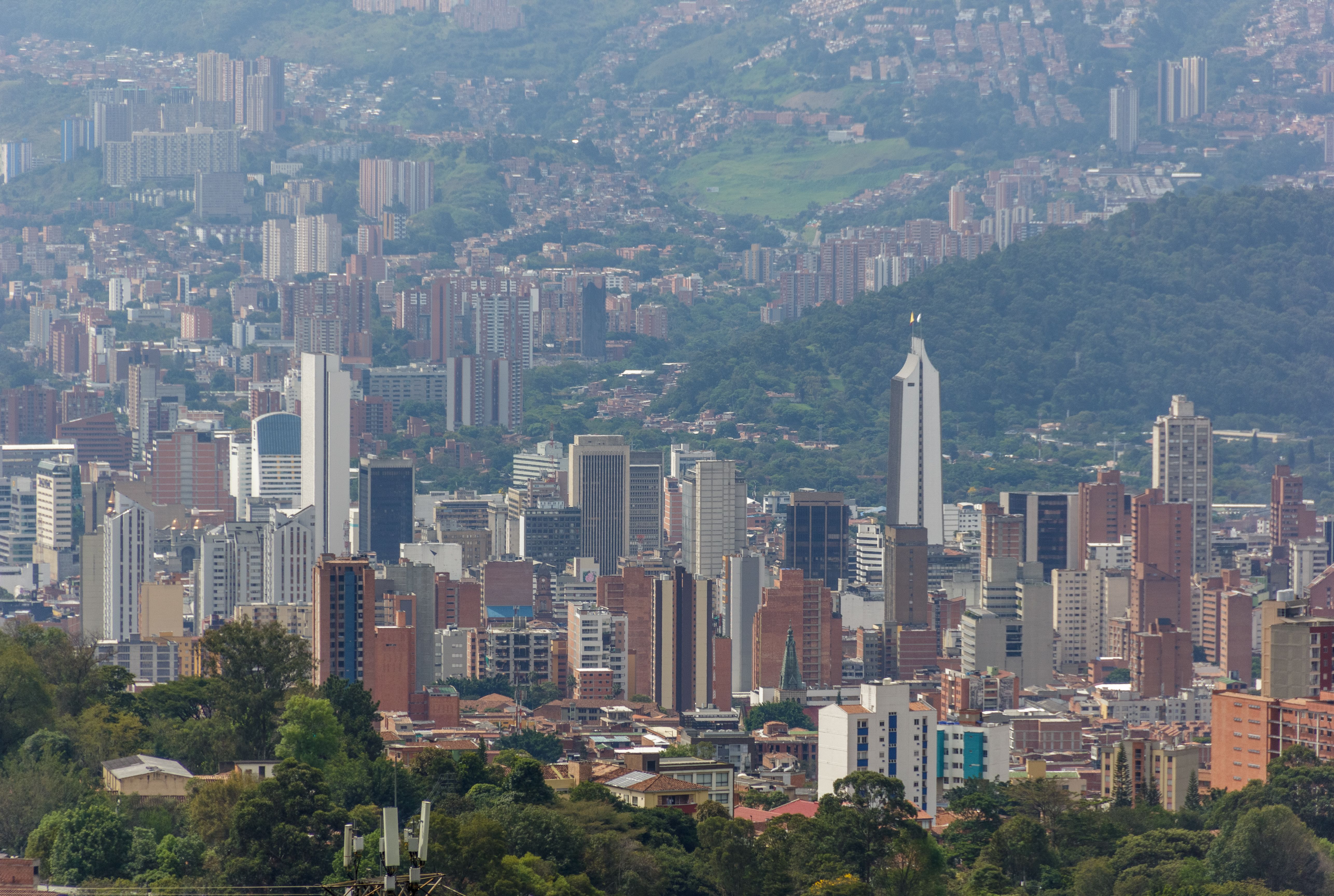 A stunning aerial view of Medellín's urban landscape, showcasing its distinctive architecture amidst lush greenery.