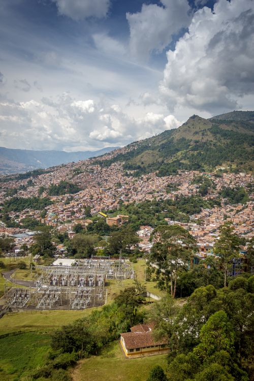 Free A breathtaking aerial photograph showcasing an expansive urban landscape against a backdrop of verdant hills. Stock Photo