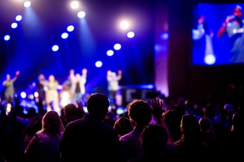 Free Energetic concert crowd with vibrant lighting at a live music event, creating a lively atmosphere. Stock Photo