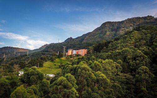 Free Scenic view of a lush green mountainous area with rural buildings in the distance. Stock Photo