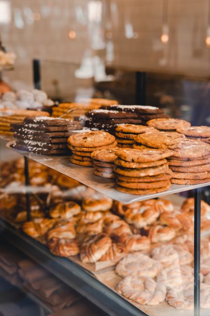 A variety of cookies neatly stacked on display in a bakery shop, showcasing gourmet pastries.
