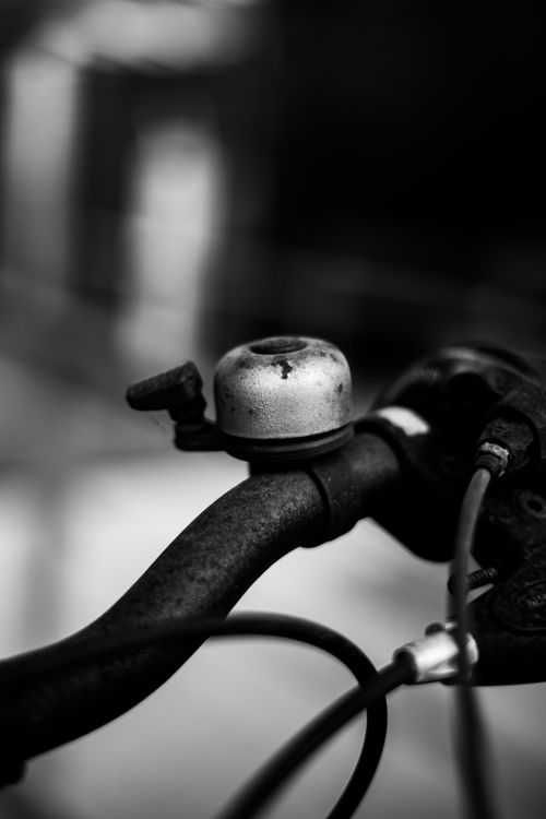 Free Artistic close-up of a vintage bicycle handlebar with bell in black and white, showcasing texture and detail. Stock Photo
