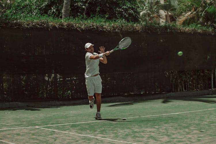 Man Playing Tennis On The Court Outdoors