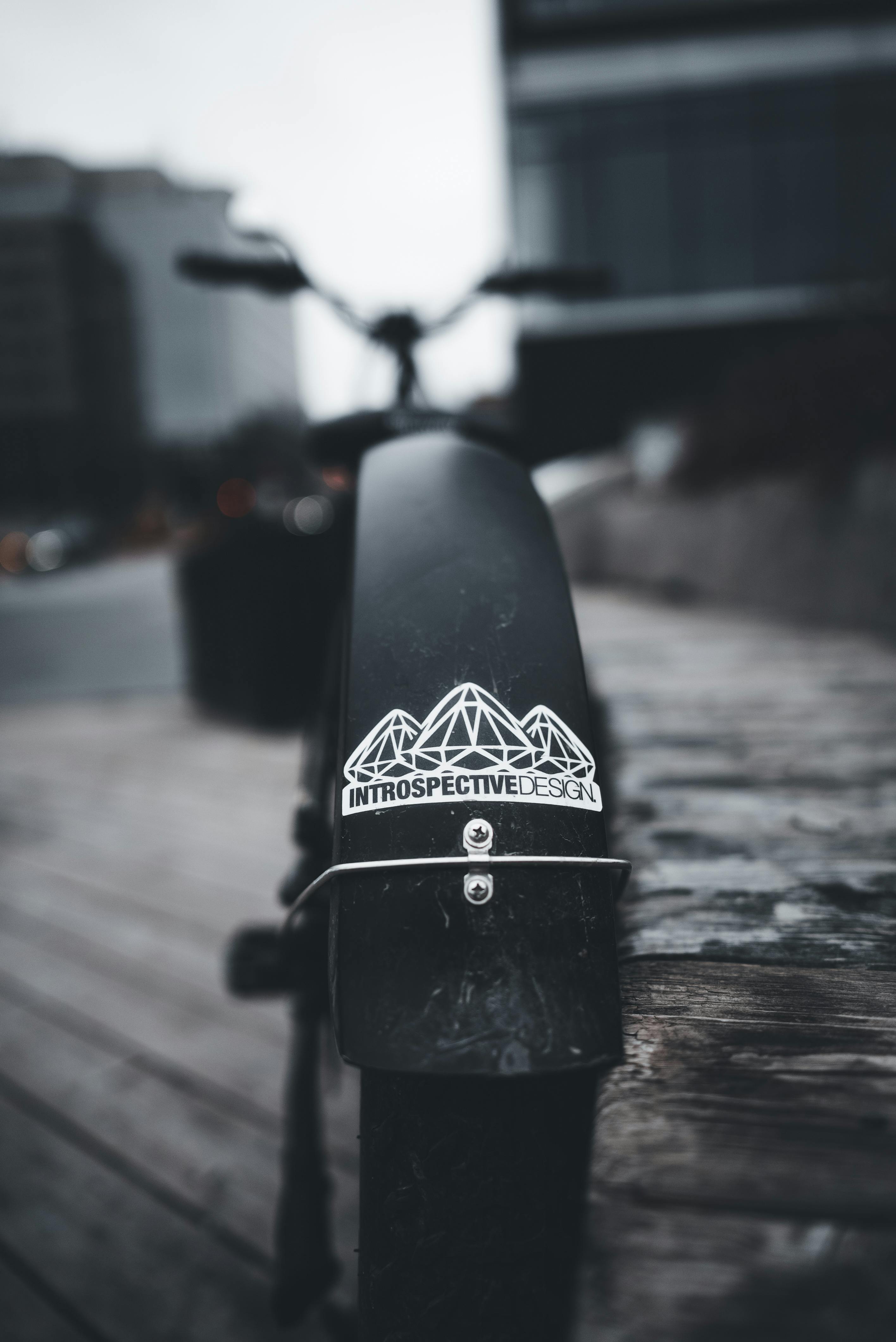 Free A stylish black bike fender captured with city streets in the background, showcasing urban design. Stock Photo