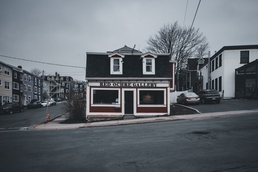 A moody street view of the Red Ochre Gallery in Newfoundland, showcasing distinct urban architecture.