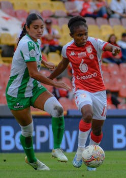 Female soccer players in intense competition on the field during a match.