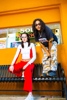Stylish young adults in vibrant clothing posing in urban setting.