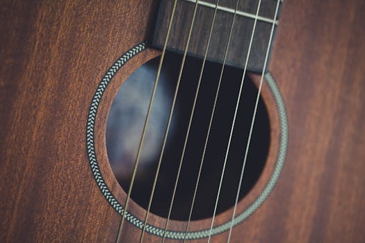 Detailed close-up of acoustic guitar strings and wood, highlighting musical instrument craftsmanship.