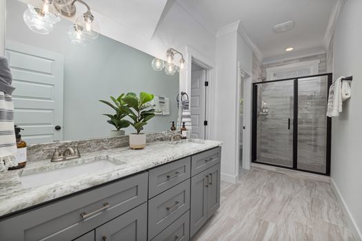 Stylish modern bathroom with minimalist design featuring a large mirror and elegant fixtures.