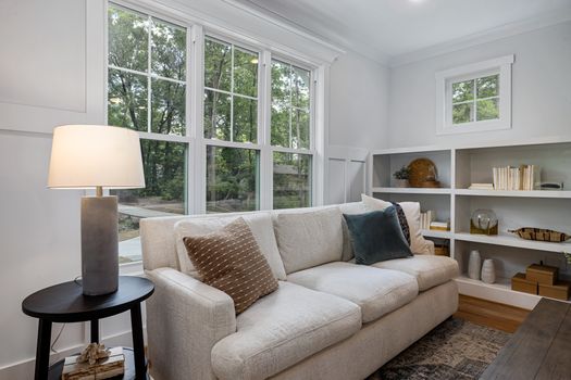 Inviting living room featuring a cozy sofa, large windows, and stylish decor.