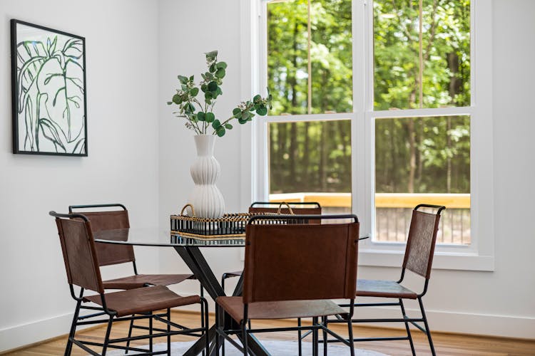 Table With Plant And Chairs Near Windows