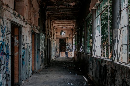 Explore the decaying, graffiti-covered corridor of an abandoned building, depicting urban exploration.