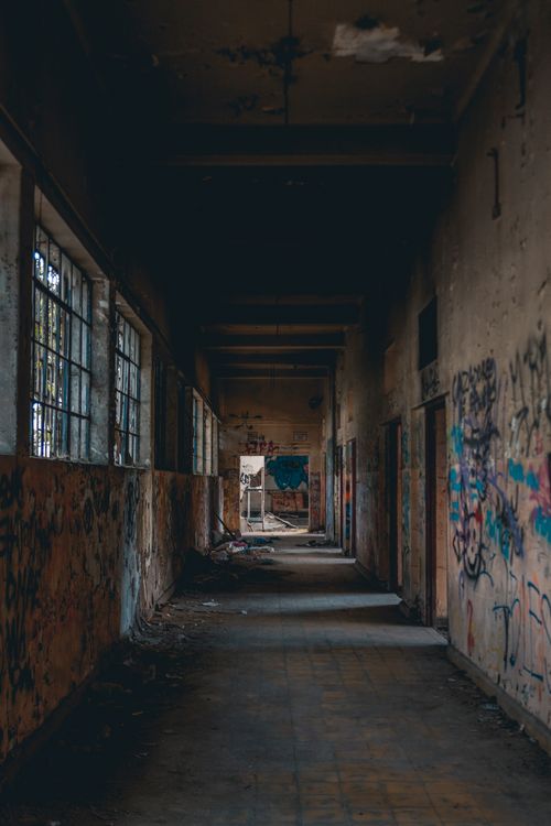 Free Rustic corridor with graffiti-covered walls in an abandoned building. Stock Photo