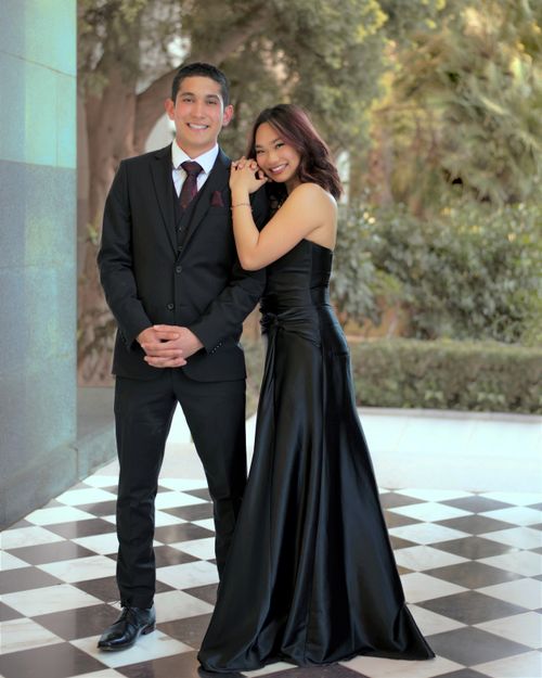 Free Elegant couple dressed in formal evening wear, posing with smiles outdoors during the day. Stock Photo
