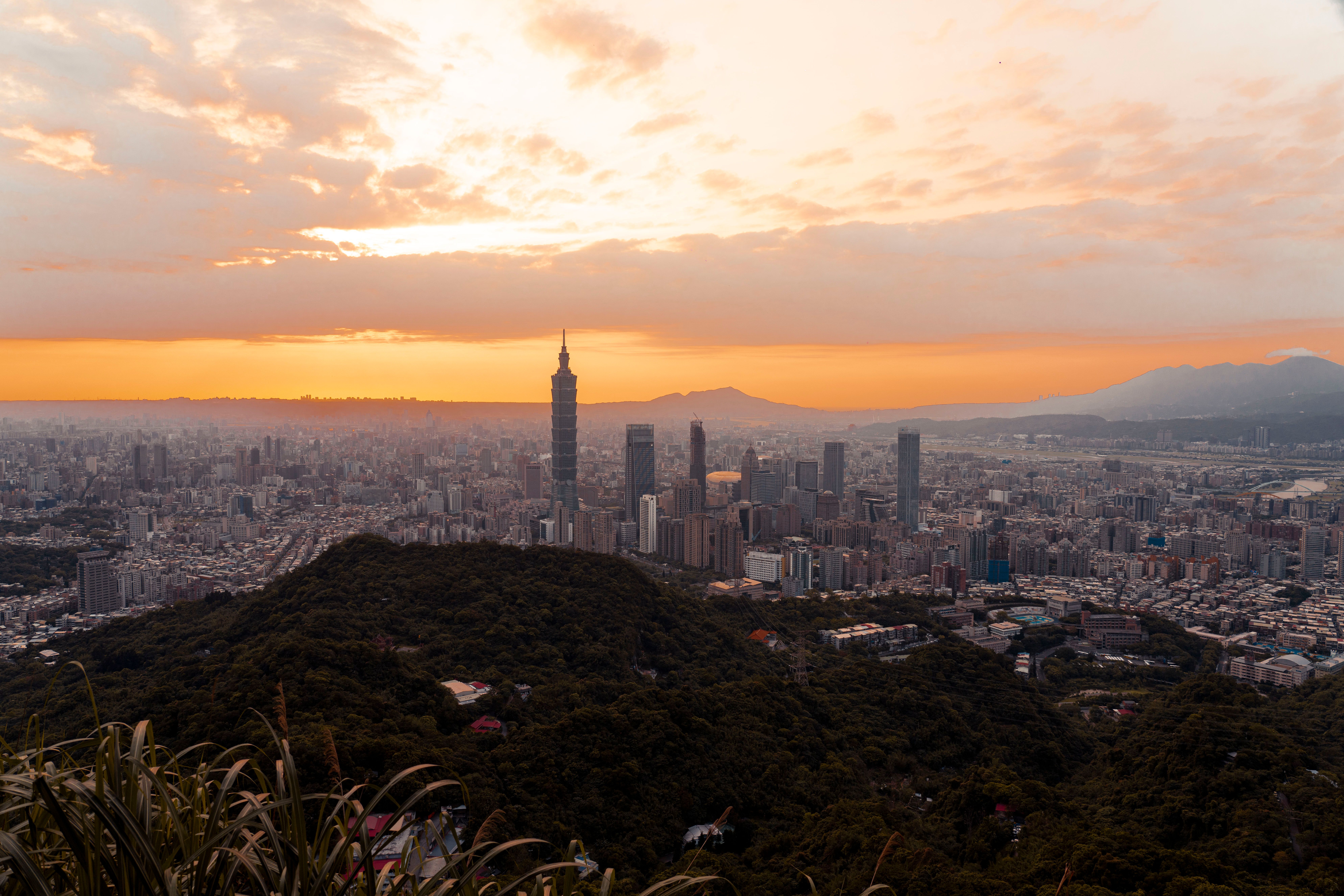 A breathtaking view of Taipei's skyline at sunset with Taipei 101 towering above the cityscape.