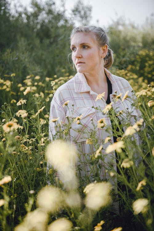 Woman Standing among Flowers on Meadow