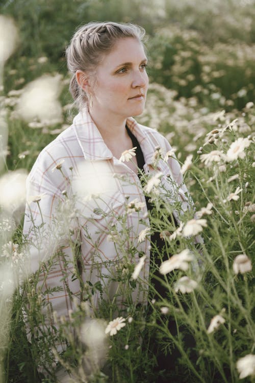 Photo of a Blonde Woman Standing in a Meadow