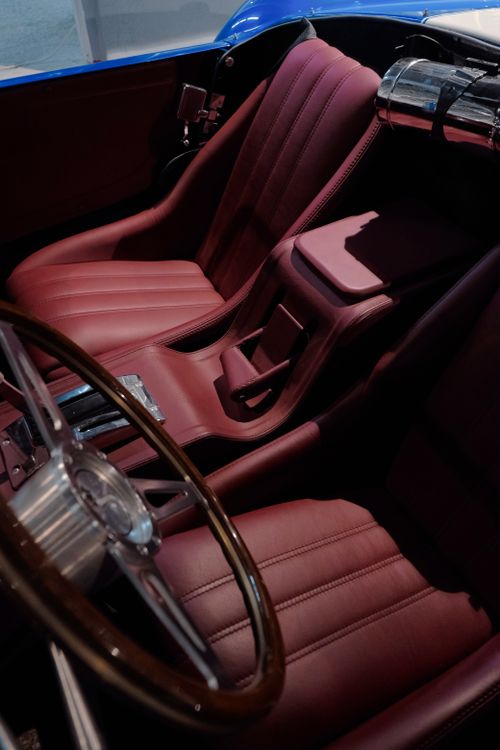Free Close-up of a luxury convertible interior with elegant maroon seats and steering wheel. Stock Photo