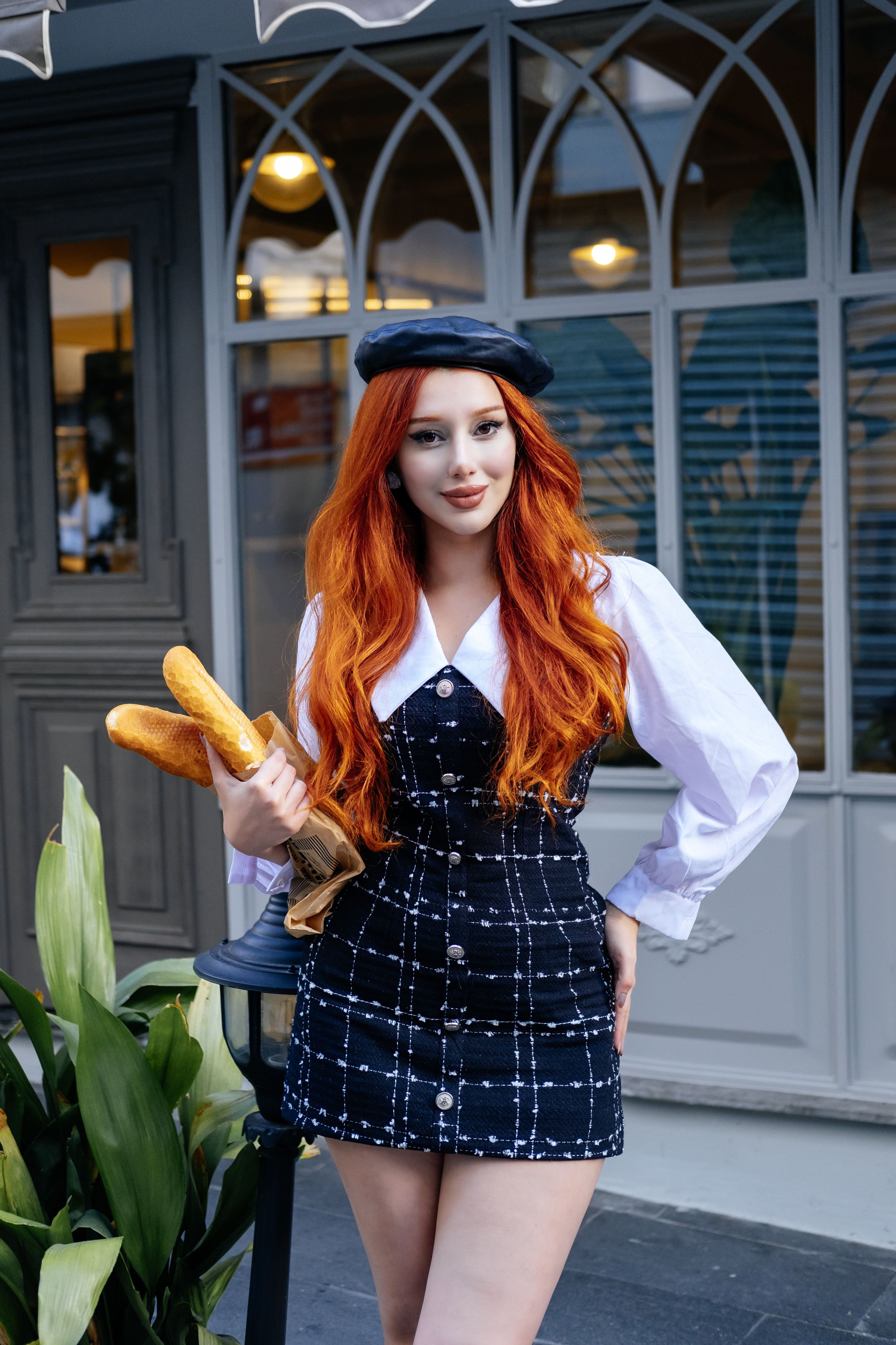 Fashionable young woman with red hair holding baguettes outdoors in Türkiye.