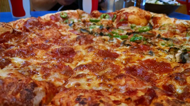 Mouthwatering close-up of a pepperoni and cheese pizza slice ready to enjoy.