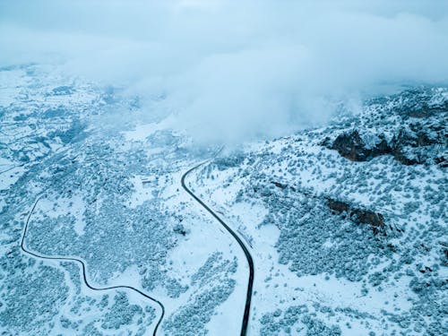 Aerial View of a Road on a Mountainside Disappearing in Thick Fog