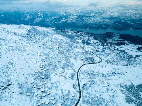 Road Through a Village on a Mountainside Buried in Snow