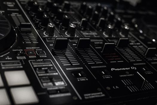 Detailed close-up of a Pioneer DJ sound mixer with knobs and faders in focus.