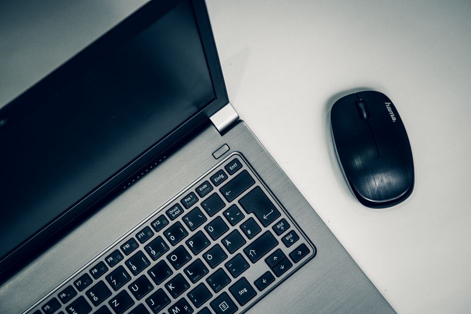 How to Choose Life Insurance Coverage Using the DIME Method Close-up of a silver laptop and black wireless mouse on a white desk.