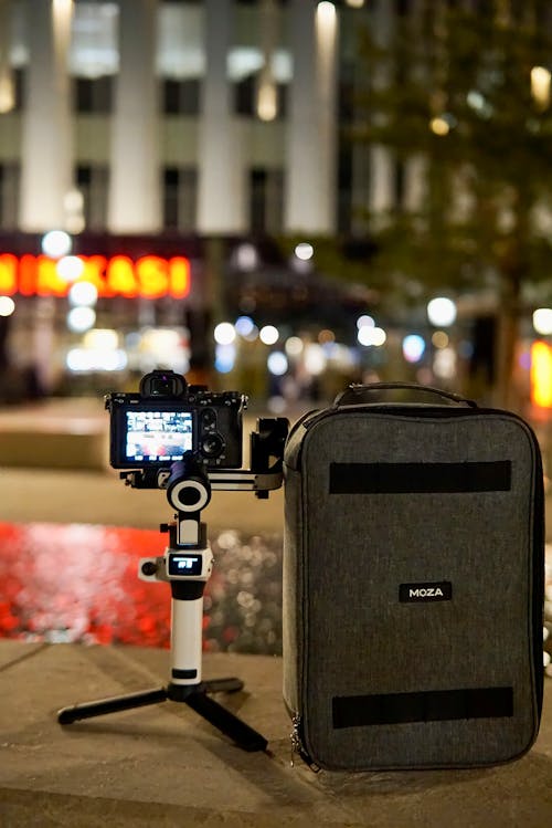 A Camera on a Tripod in City in the Evening 