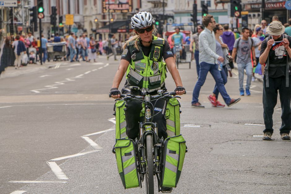Emergency responder on bike navigates a bustling street in London, UK.